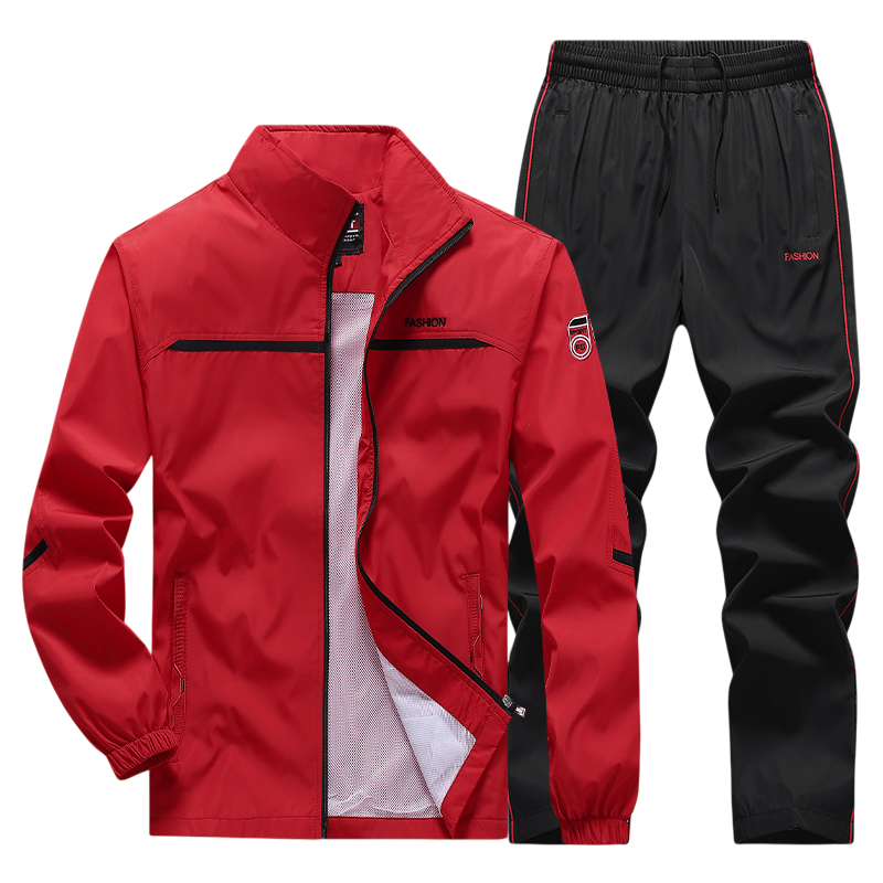 Dres komplet męski dwuczęściowy Arkadya Outlet: czerwona bluza na zamek z czarnymi akcentami i czarne spodnie z czerwonymi lampasami, wykonane z lekkiego materiału.