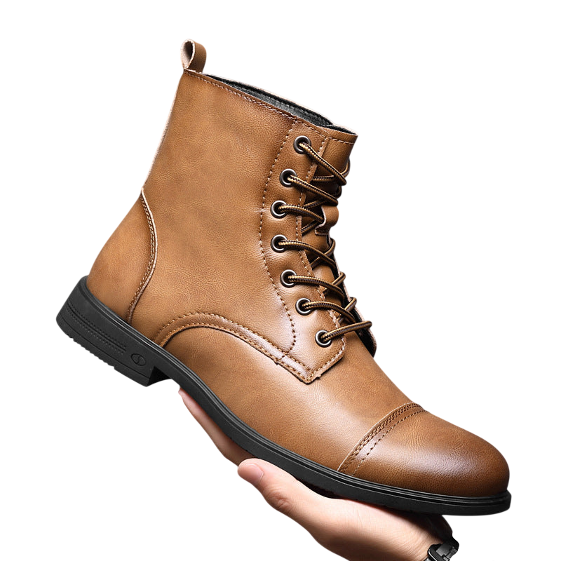 Ręka trzyma Arkadya Outlet Buty męskie wysoka cholewka z wiązaniem pełna wysokość - brązowe skórzane sznurowane buty z zakrytym czubkiem i czarną podeszwą - wyświetlane na jednolitym szarym tle.