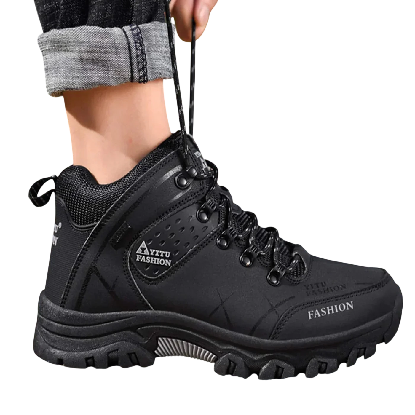 Mężczyzna w Arkadia Outlet Męskie buty wodoodporna konstrukcja ergonomiczna podeszwa stoi na skałach na zewnątrz. Czarne, sznurowane buty z grubą podeszwą i podwinięte jeansy to idealne buty do codziennego użytkowania.