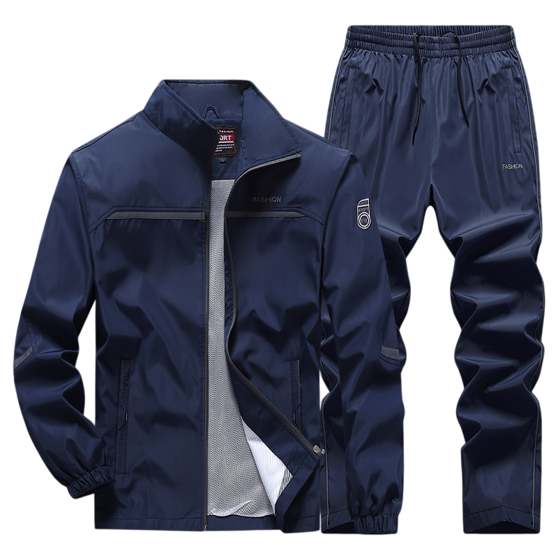 Dres komplet męski dwuczęściowy bluza na zamek i spodnie od Arkadya Outlet to ciemnoniebieski zestaw z lekkiego, połyskującego materiału: bluza ze stójką i ściągaczami plus dopasowane spodnie ze ściągaczem i troczkiem, całość w sportowym stylu.