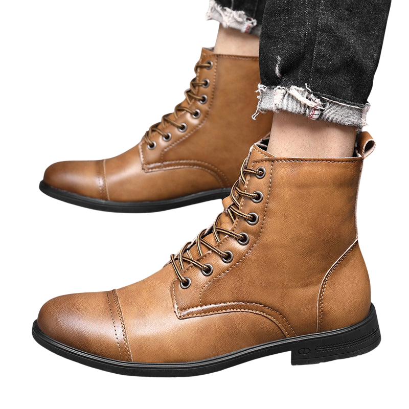 Osoba ubrana w czarne jeansy z postrzępionymi obszyciami i Arkadya Outlet Buty męskie wysoka cholewka z wiązaniem pełna wysokość w kolorze jasnobrązowym stoi na szarej podłodze wyłożonej kafelkami. Buty mają zaokrąglony nosek i widoczne szwy.