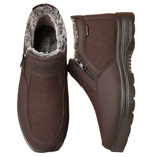 Para butów Arkadya Outlet Buty męskie ocieplane zimowe z podeszwą antypoślizgową w kolorze brązowym, z bocznymi suwakami i ciepłą szarą podszewką. Jeden but stoi pionowo, pokazując bok, drugi leży płasko, aby odsłonić widok z góry i przytulne wnętrze.
