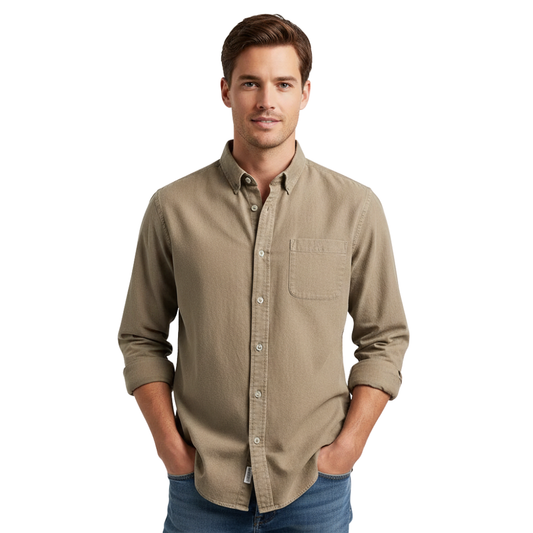 Mężczyzna z krótkimi brązowymi włosami nosi Arkadya Outlet koszula męska klasyczny krój proste linie regularna długość i niebieskie dżinsy, stojąc z rękami w kieszeniach na białym tle - idealny strój do pracy biurowej.