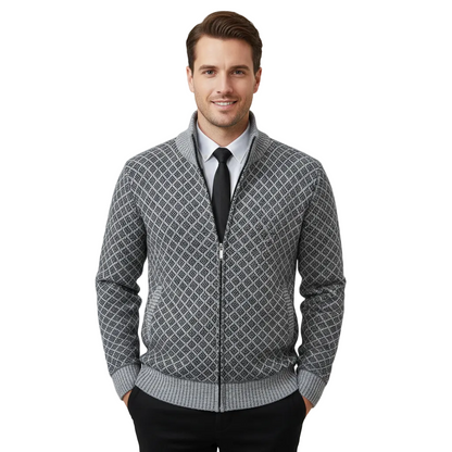 Uśmiechnięty mężczyzna o krótkich brązowych włosach, ubrany w kurtkę Arkadya Outlet Męska Klasyczny Luźny Krój Strukturalna Warstwowa Konstrukcja na białej koszuli i czarnym krawacie, z rękami w kieszeniach, na jednolitym jasnym tle.