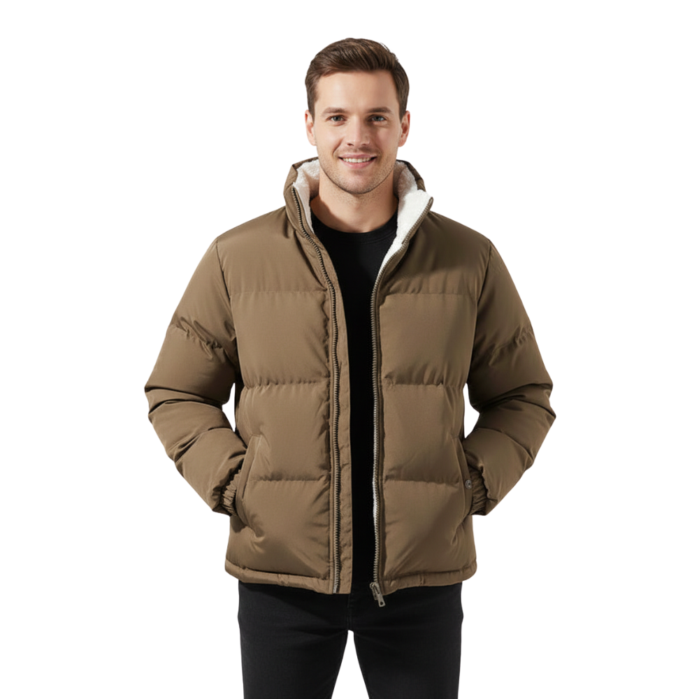 Mężczyzna o krótkich brązowych włosach uśmiecha się, mając na sobie Arkadya Outlet Kurtka Męska Pikowana Konstrukcja Z Przymocowanym Kapturem, czarne spodnie i czarną koszulę, stojąc z rękami w kieszeniach kurtki na białym tle.