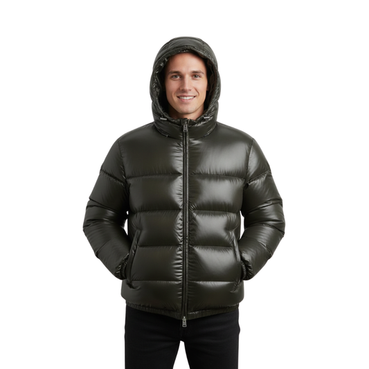 Mężczyzna ubrany w Arkadya Outlet Kurtka Pikowana Męska Krótka Długość Konstrukcja Komorowa z kapturem pozuje z rękami w kieszeniach, uśmiechając się do kamery na jednolitym białym tle.