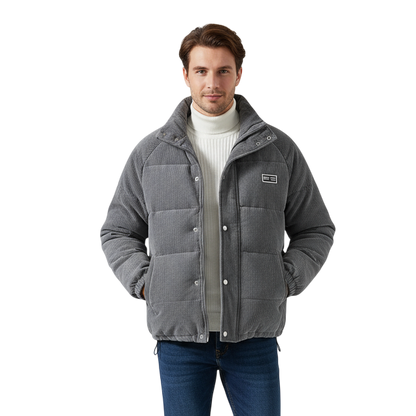 Mężczyzna w Arkadia Outlet Kurtka zimowa męska strukturalny krój z czystymi liniami, biały golf, niebieskie dżinsy i białe trampki stoi z rękami w kieszeniach kurtki na białym tle.