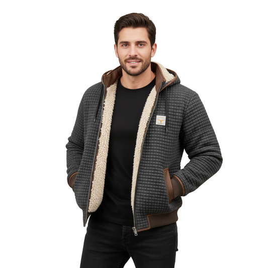 Mężczyzna z krótkimi brązowymi włosami i brodą ma na sobie czarną koszulkę i Arkadya Outlet Lekka Kurtka Pikowana Męska Luźny Krój Wysoki Kołnierz, stoi z rękami w kieszeniach i uśmiecha się do kamery.