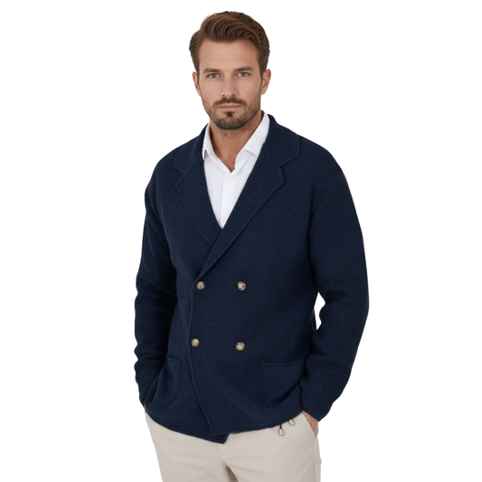 Mężczyzna z krótkimi brązowymi włosami i brodą nosi kurtkę Arkadya Outlet kardigan męski dwurzędowy krój typu marynarka z kołnierzem na białej koszuli i beżowych spodniach, stojąc z jedną ręką w kieszeni na białym tle.