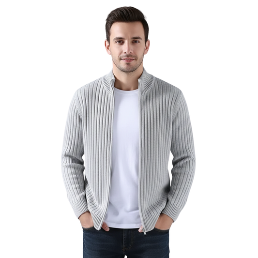 Mężczyzna z krótkimi ciemnymi włosami nosi Arkadya Outlet Kardigan Męski Dzianinowy Prążkowana Faktura Zamek Długi Rękaw na białej koszulce i ciemnych dżinsach, stojąc z rękami w kieszeniach na białym tle.