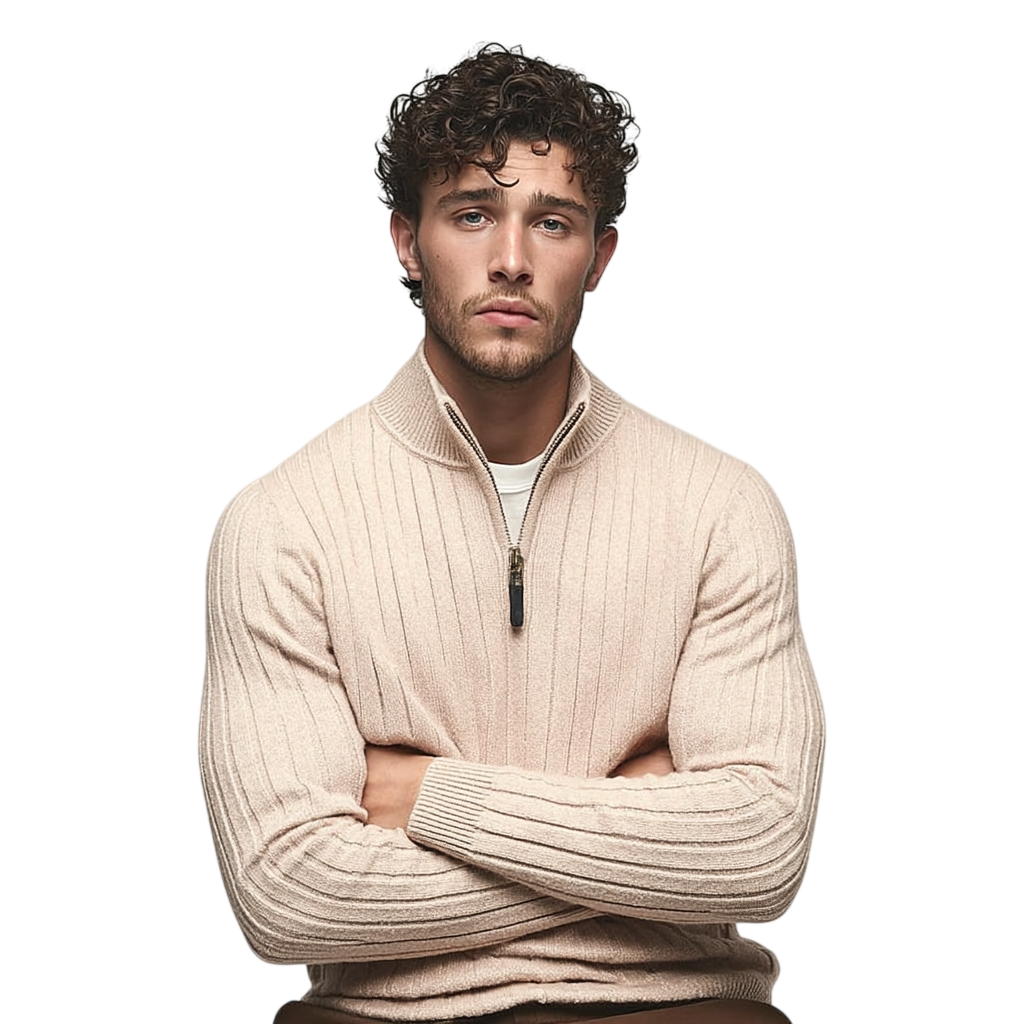 Mężczyzna z kręconymi brązowymi włosami i przystrzyżoną brodą siedzi ze skrzyżowanymi ramionami, ubrany w męski półzamek dopasowany krój kołnierz stojący długi rękaw Arkadya Outlet na jasnobeżowym tle.