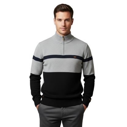 Mężczyzna o krótkich brązowych włosach i neutralnym wyrazie twarzy ma na sobie ciemne spodnie i Arkadya Outlet Sweter dzianinowy męski zamek ćwierć lekki długi rękaw w kolorze szaro-czarnym z marynarskim paskiem, wykonany z lekkiej dzianiny.
