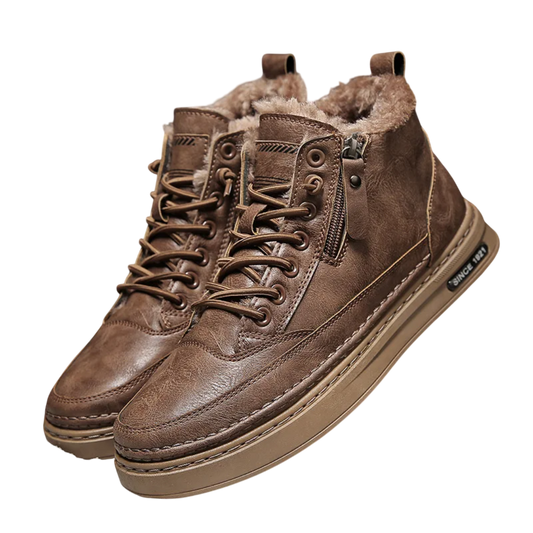 Para butów Arkadya Outlet Botki męskie sznurowane z bocznym zamkiem na wysokość kostki jest pokazana na piaszczystej powierzchni z rozrzuconymi liśćmi, z podszewką ze sztucznego futra i teksturowanymi podeszwami.