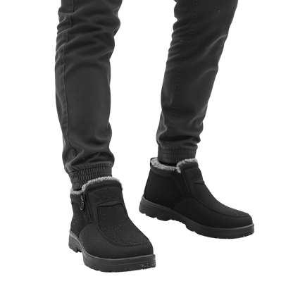 Osoba w ciemnych spodniach nosi Arkadya Outlet Męskie buty wodoodporne antypoślizgowe zimowe obuwie, stojąc na ośnieżonej ziemi z drzewami w tle.