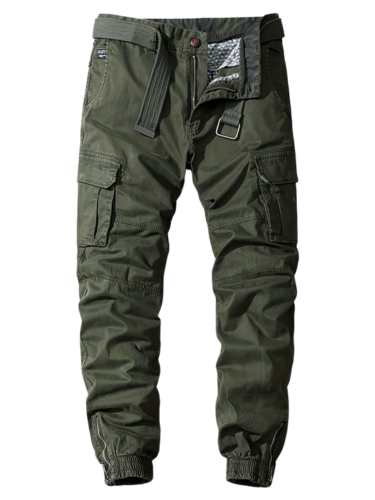 Oliwkowe joggery Arkadya Outlet Męskie Spodnie mają kieszenie cargo, czarny pasek, rozporek zapinany na zatrzask, elastyczne mankiety przy kostkach i częściowo widoczną pikowaną podszewkę w pasie.