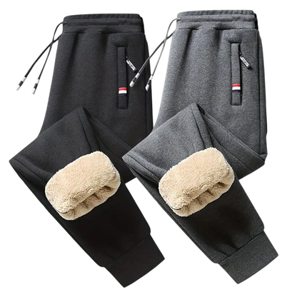Dwie pary Arkadya Outlet Spodnie Termiczne Męskie Elastyczny Pas Z Regulacją W Talii w kolorze czarnym i ciemnoszarym, każda z kieszenią zapinaną na zamek, kolanami wyściełanymi polarem, regulowanym ściągaczem w pasie i prążkowanymi mankietami - idealne na chłodne dni.