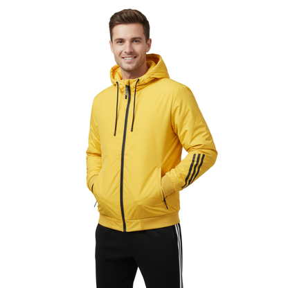 Uśmiechnięty mężczyzna stoi z rękami w kieszeniach na białym tle, ubrany w Arkadya Outlet męski zestaw dresowy dwuczęściowy komplet sportowy z bluzą-żółtą bluzą z kapturem z czarnymi ściągaczami i rękawami w paski, w połączeniu z czarnymi spodniami.