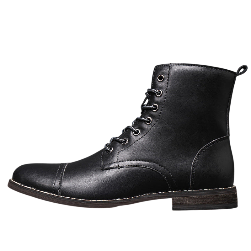 Buty męskie Arkadya Outlet to czarne, skórzane, sznurowane buty za kostkę z noskiem w szpic, bocznymi przeszyciami i niską brązową podeszwą, przedstawione na podłodze wyłożonej kafelkami na szarym tle.