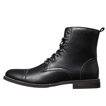 Buty męskie Arkadya Outlet to czarne, skórzane, sznurowane buty za kostkę z noskiem w szpic, bocznymi przeszyciami i niską brązową podeszwą, przedstawione na podłodze wyłożonej kafelkami na szarym tle.