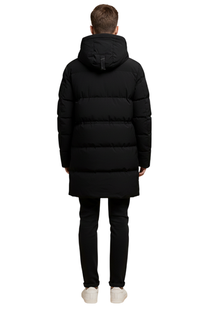 Osoba stojąca pewnie w Arkadya Outlet Kurtka Parka Męska Długa Pikowana z Kapturem Zimowa Ochronna, ciesząc się zarówno stylem, jak i komfortem w tej ciepłej, ochronnej kurtce zimowej.