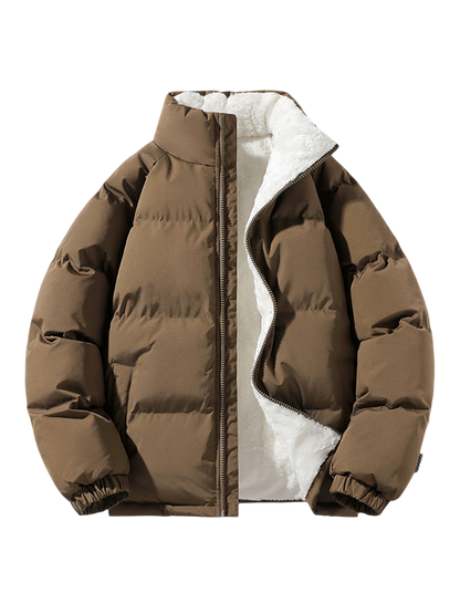 Kurtka Męska Pikowana Konstrukcja Z Przymocowanym Kapturem marki Arkadya Outlet to brązowy puffer z wysokim kołnierzem, elastycznymi mankietami, białą pluszową polarową podszewką i częściowo rozpinanym przodem, przedstawiony na jasnoszarym tle.