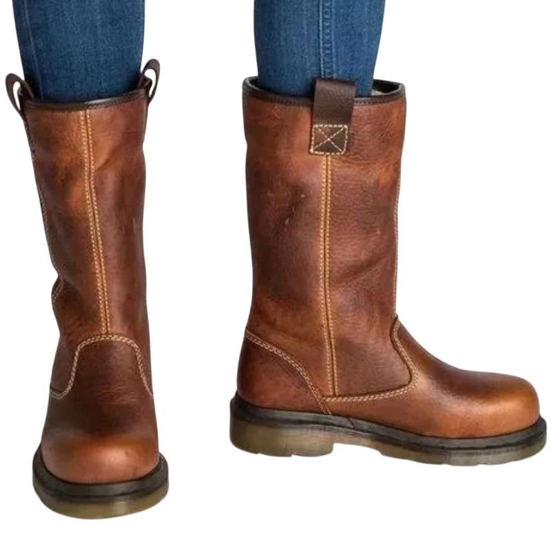 Mężczyzna w niebieskich dżinsach nosi Arkadya Outlet Buty za kostkę męskie wsuwane z okrągłym noskiem i podeszwą, z widocznymi szwami, stojący na białym tle.