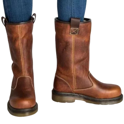 Mężczyzna w niebieskich dżinsach nosi Arkadya Outlet Buty za kostkę męskie wsuwane z okrągłym noskiem i podeszwą, z widocznymi szwami, stojący na białym tle.