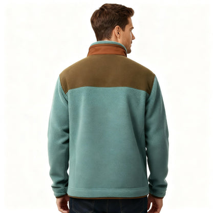 Mężczyzna o krótkich brązowych włosach modeluje Kurtkę Męską Prosty Krój Lekka Odzież Wierzchnia Z Długim Rękawem Arkadya Outlet - jasnoniebieską i oliwkowozieloną bluzę polarową z brązowym kołnierzem - w połączeniu z niebieskimi dżinsami, stojąc na prostym, jasnym tle.