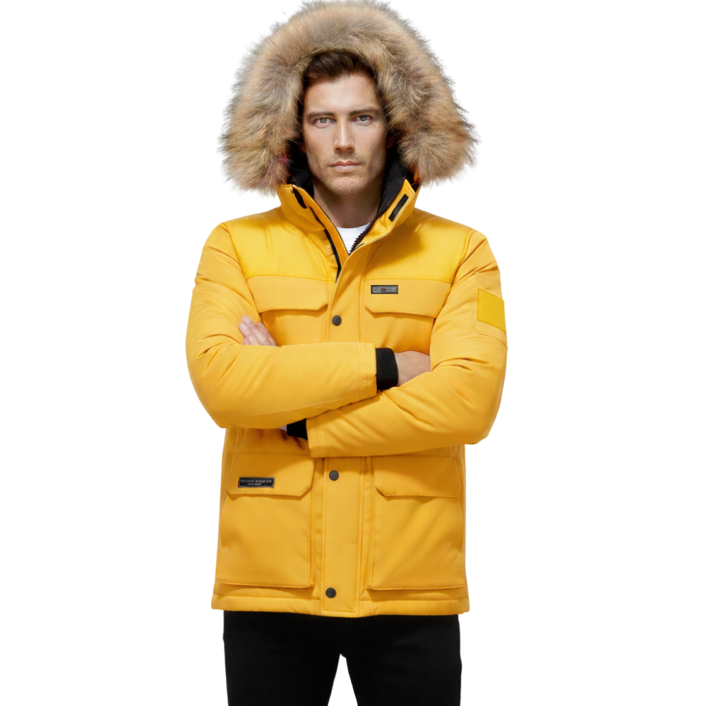 Mężczyzna nosi kurtkę Arkadya Outlet Kurtka Męska Ocieplana z Kapturem na Zimę, w jaskrawożółtym kolorze i z kapturem obszytym futrem, stojąc ze skrzyżowanymi ramionami na prostym białym tle.