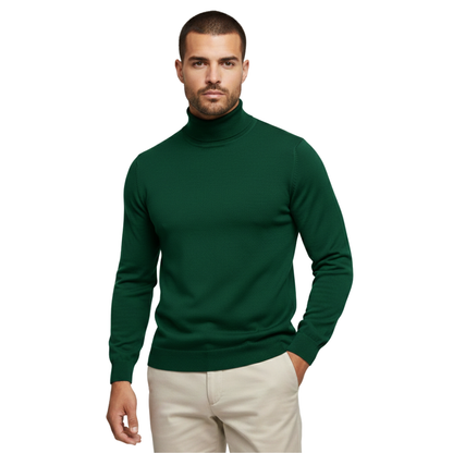 Mężczyzna ubrany w męski golf Arkadya Outlet Sweter długi rękaw dopasowany pulower w kolorze ciemnozielonym i jasnobeżowe spodnie, stojący na jednolitym białym tle i patrzący w kamerę z jedną ręką w kieszeni.