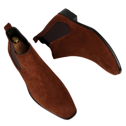 Botki męskie wsuwane z kwadratowym noskiem i niskim obcasem marki Arkadya Outlet z brązowego zamszu, z czarnymi podeszwami, elastycznymi panelami bocznymi i zakładkami, prezentowane na białym tle.