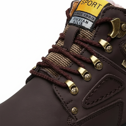 Zbliżenie na męskie buty zimowe wodoodporne ocieplane obuwie na chłodne dni Arkadya Outlet ze złotymi oczkami, brązowymi sznurowadłami, widocznymi szwami i żółtą etykietą SPORT SINCE 1982 XIXIAN KLIE - idealne na przygody na świeżym powietrzu.