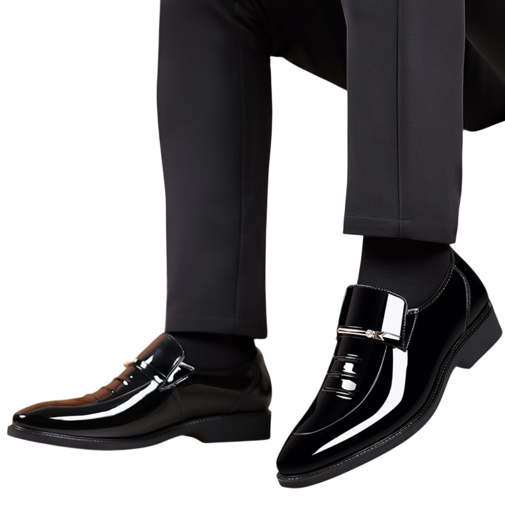 Osoba ubrana w czarne spodnie i Arkadya Outlet Mokasyny Wizytowe Męskie Wsuwany Szpiczasty Nosek, pokazana od kolan w dół na białym tle.