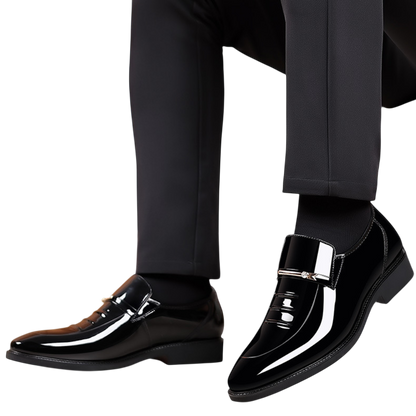 Osoba ubrana w czarne spodnie i Arkadya Outlet Mokasyny Wizytowe Męskie Wsuwany Szpiczasty Nosek, pokazana od kolan w dół na białym tle.