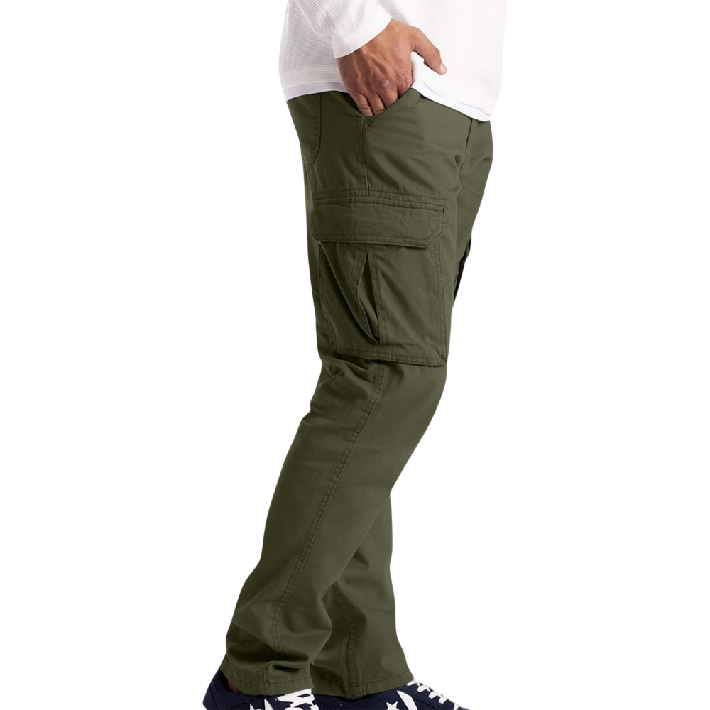 Osoba stoi z profilu na białym tle, ubrana w Arkadya Outlet Spodnie cargo męskie luźny krój z kieszeniami na dzień codzienny, białą koszulę z długim rękawem i ciemne buty sportowe z białymi podeszwami.