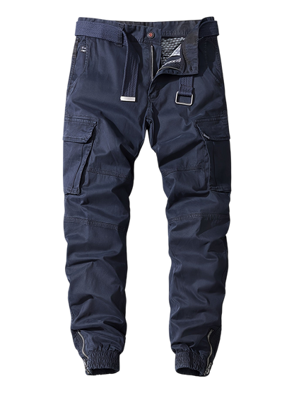 Arkadya Outlet Męskie Spodnie joggery w kolorze granatowym z kieszeniami cargo, materiałowym paskiem i elastycznymi mankietami w kostkach są pokazane na gładkim szarym tle.