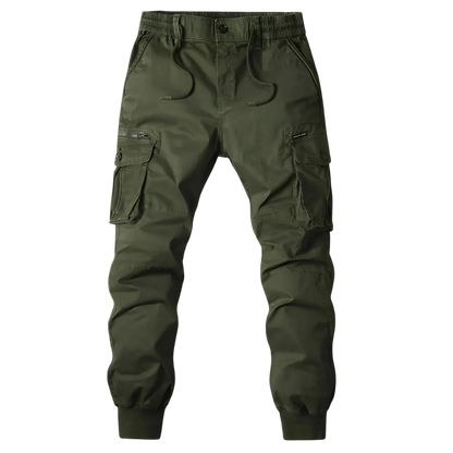 Arkadya Outlet Spodnie Cargo Męskie Kieszenie Na Zamek, pas elastyczny i ściągacze przy nogawkach prezentowane na tle rozmazanej panoramy miasta.