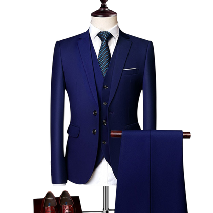 Komplet trzyczęściowy męski dopasowany zestaw odzieży marki Arkadya Outlet jest prezentowany na manekinie z dopasowanymi spodniami, białą koszulą, niebieskim krawatem w paski i brązowymi butami wizytowymi.