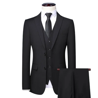 Zestaw Garniturowy Męski Trzyczęściowy Z Marynarką I Kamizelką Arkadya Outlet: czarny garnitur, biała koszula i czarny krawat na manekinie, spodnie na wieszaku, całość na jasnoszarym tle. Idealny wybór na formalne okazje.