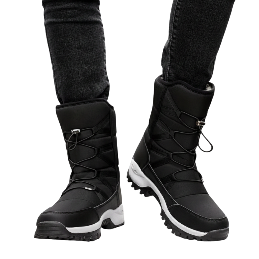 Osoba ma na sobie Arkadya Outlet Buty Śniegowe Męskie z grubymi podeszwami, białymi akcentami i krzyżującymi się sznurowadłami, w połączeniu z ciemnymi dżinsami. Te wytrzymałe wodoodporne buty są idealne na zimną lub śnieżną pogodę.