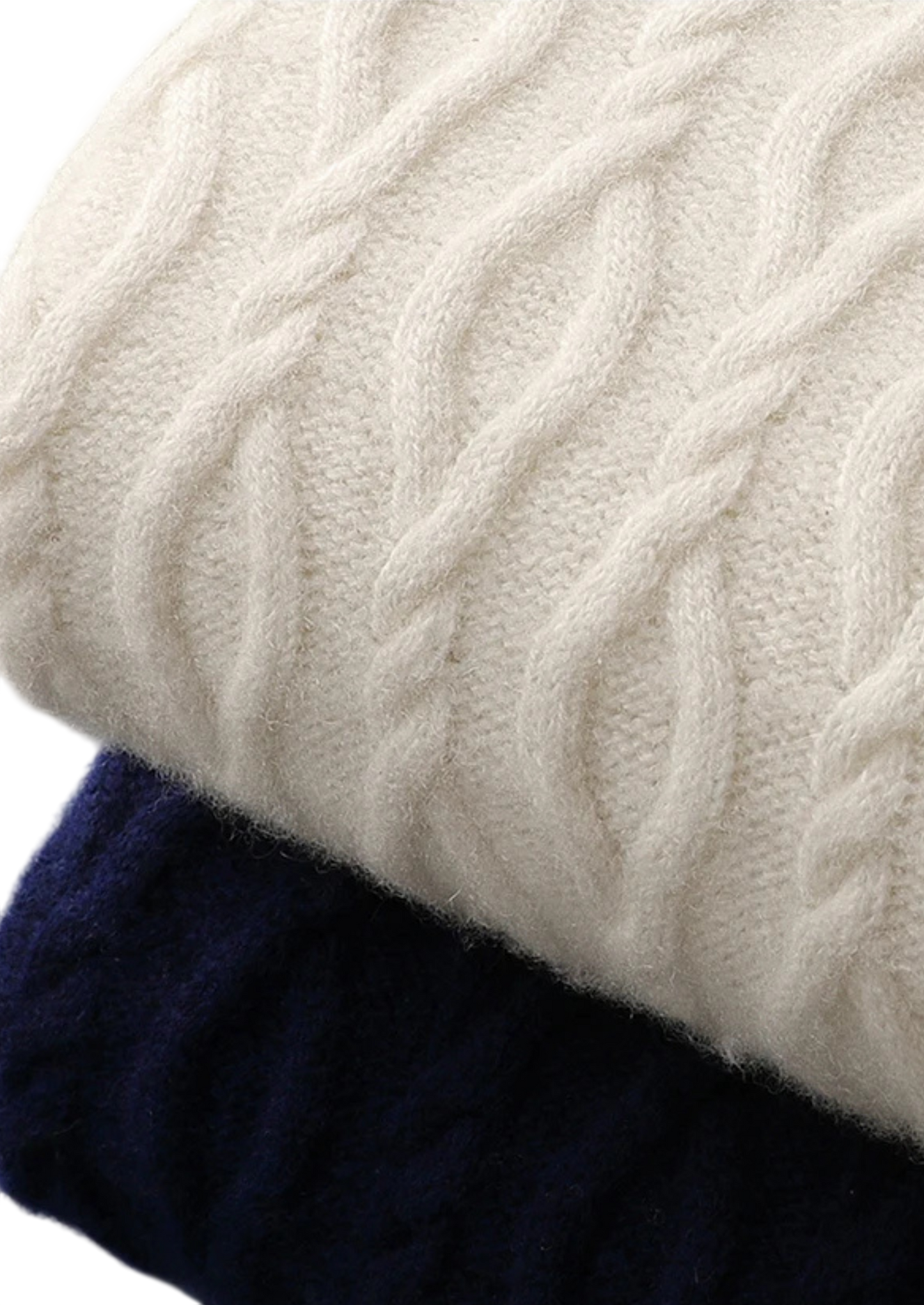 Zbliżenie na dwie złożone swetry męskie Arkadya Outlet, model "Sweter męski dekolt okrągły kontrastowa lamówka", jedna kremowa na wierzchu, druga granatowa pod spodem, podkreślające fakturowaną dzianinę i klasyczny męski styl.