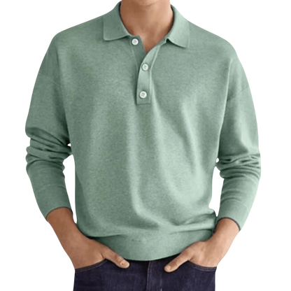 Osoba (twarz niewidoczna) nosi koszulkę polo Arkadya Outlet Koszulka męska długi rękaw półguziki kołnierz wzór w kolorze jasnozielonym z ciemnymi dżinsami, ręce w kieszeniach.