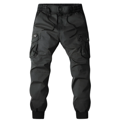 Arkadya Outlet Spodnie Cargo Męskie Kieszenie Na Zamek Pas Elastyczny z wieloma kieszeniami i elastycznymi mankietami, pokazane na tle rozmytego miejskiego krajobrazu.
