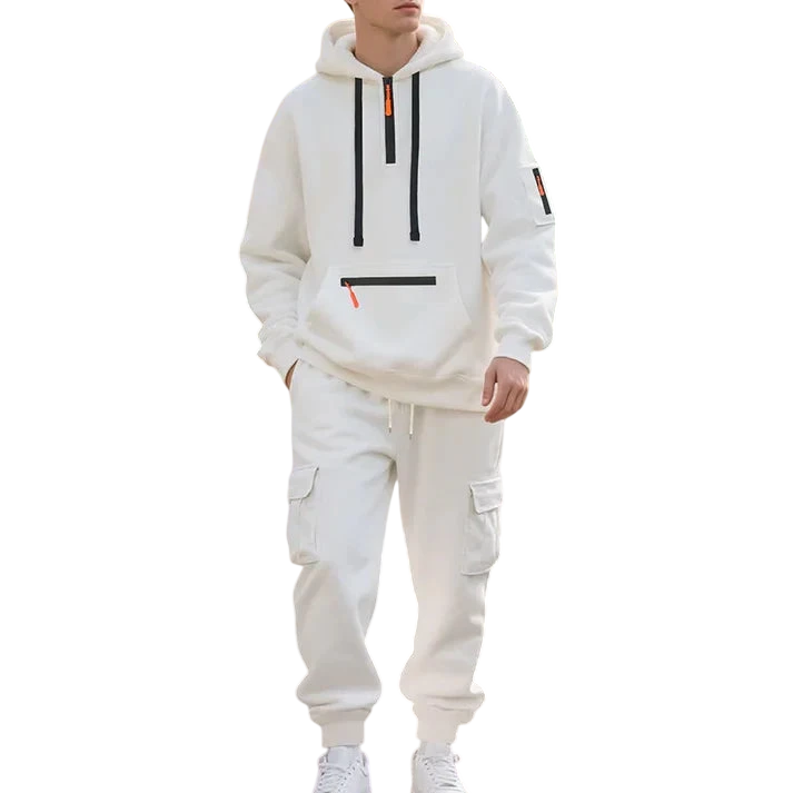 Osoba w Arkadii Outlet Męski dres wyściełane wnętrze dwuczęściowy komplet z zamkiem idzie wzdłuż parkowej ścieżki wyłożonej drzewami i kwiatami w słoneczny dzień.