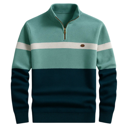 Męski sweter Arkadya Outlet to kolorowy sweter męski ze stójką zapinaną do połowy na zamek błyskawiczny, w odcieniach turkusu, z białym paskiem na piersi, małą brązową naszywką po lewej stronie oraz prążkowanymi mankietami i dołem.