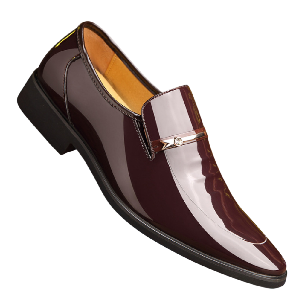 Arkadya Outlet Mokasyny Wizytowe Męskie Wsuwany Szpiczasty Nosek to błyszczący bordowy męski wsuwany loafers ze spiczastym noskiem, czarną podeszwą i metalicznymi detalami na całej cholewce, pokazany na białym tle.