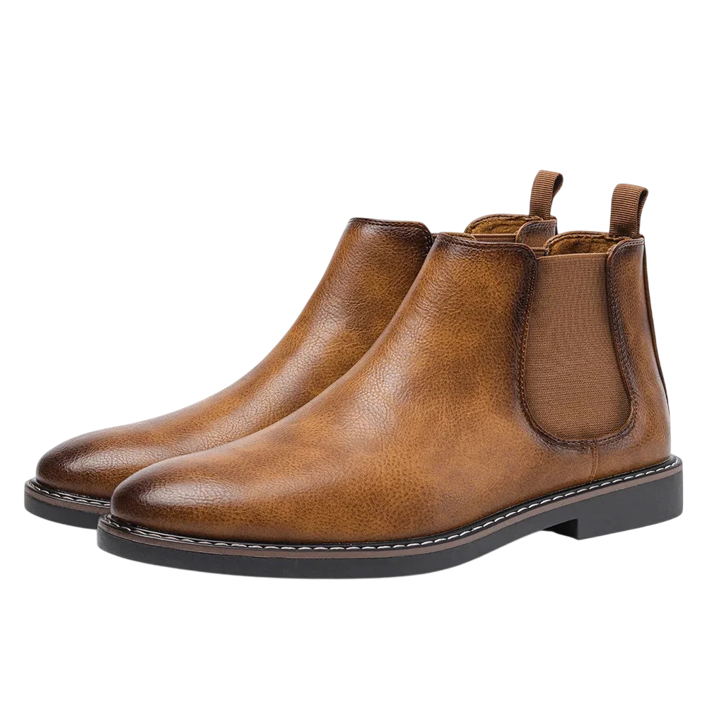 Arkadya Outlet Botki męskie wsuwane sztyblety zimowe zamknięta forma to brązowe skórzane męskie buty Chelsea z elastycznymi panelami bocznymi, zakładkami z tyłu i czarnymi gumowymi podeszwami, pokazane na białym tle.