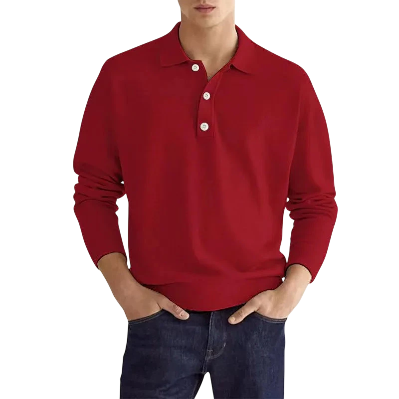 Mężczyzna nosi koszulkę polo Arkadya Outlet Koszulka męska długi rękaw półguziki kołnierz wzór w kolorze czerwonym z białymi guzikami i klasycznym kołnierzem, w połączeniu z ciemnoniebieskimi dżinsami, stojąc z rękami w kieszeniach na jednolitym białym tle.