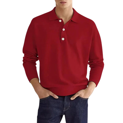 Mężczyzna nosi koszulkę polo Arkadya Outlet Koszulka męska długi rękaw półguziki kołnierz wzór w kolorze czerwonym z białymi guzikami i klasycznym kołnierzem, w połączeniu z ciemnoniebieskimi dżinsami, stojąc z rękami w kieszeniach na jednolitym białym tle.
