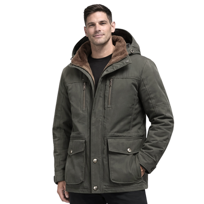 Mężczyzna w ciemnozielonej Kurtce Zimowej Męskiej z Kapturem i Kieszeniami marki Arkadya Outlet, z brązową podszewką, wieloma kieszeniami i dużymi guzikami, stoi uśmiechnięty z jedną ręką w kieszeni.